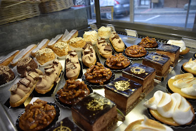 Vitrine de pâtisseries : éclairs, tartelettes, entremets et meringues faits maison